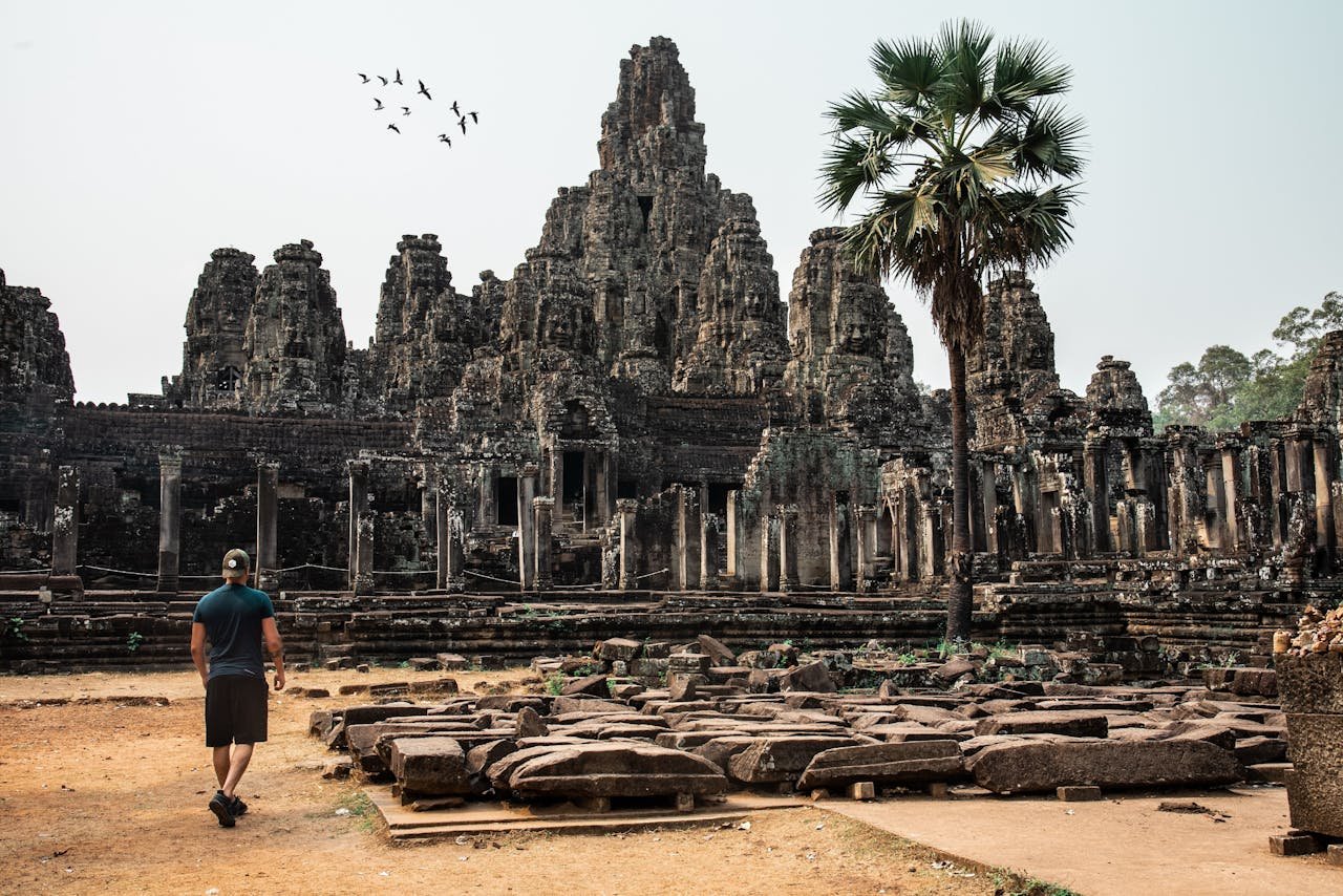 Mastering the First Impression: Your intriguing post title goes here Traveler exploring the ancient Bayon Temple at Angkor Thom, Cambodia, surrounded by stunning architecture.